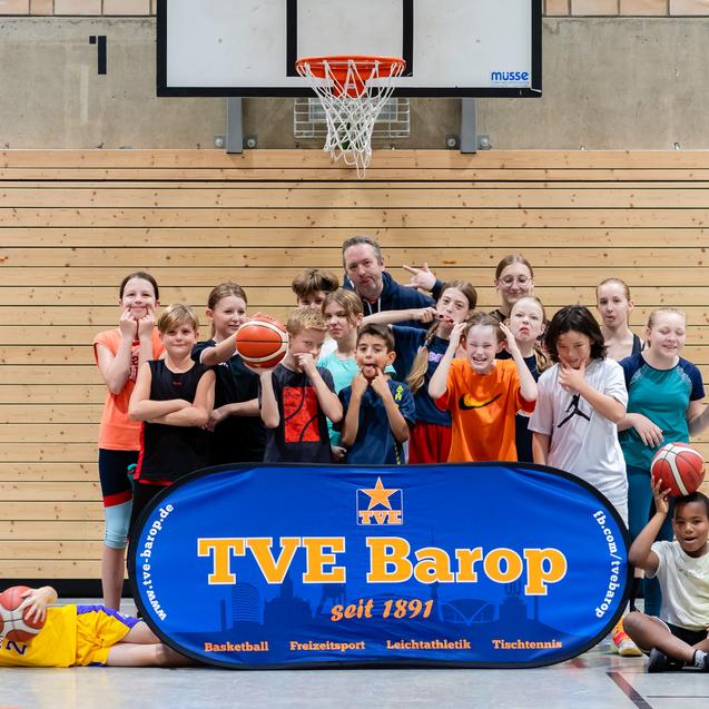 Gruppe von Kindern mit Basketballs vor einem Korb, Banner mit „TVE Barop seit 1891“ im Vordergrund.