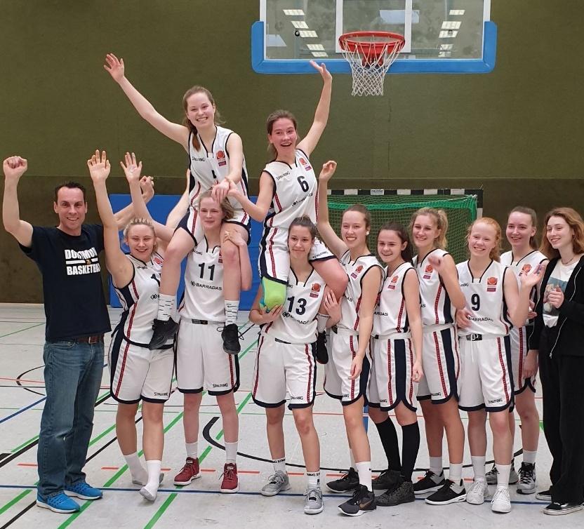 U18 Mädchen 2018 Eine Basketballmannschaft feiert mit erhobenen Händen, während eine Spielerin auf den Schultern einer anderen sitzt.