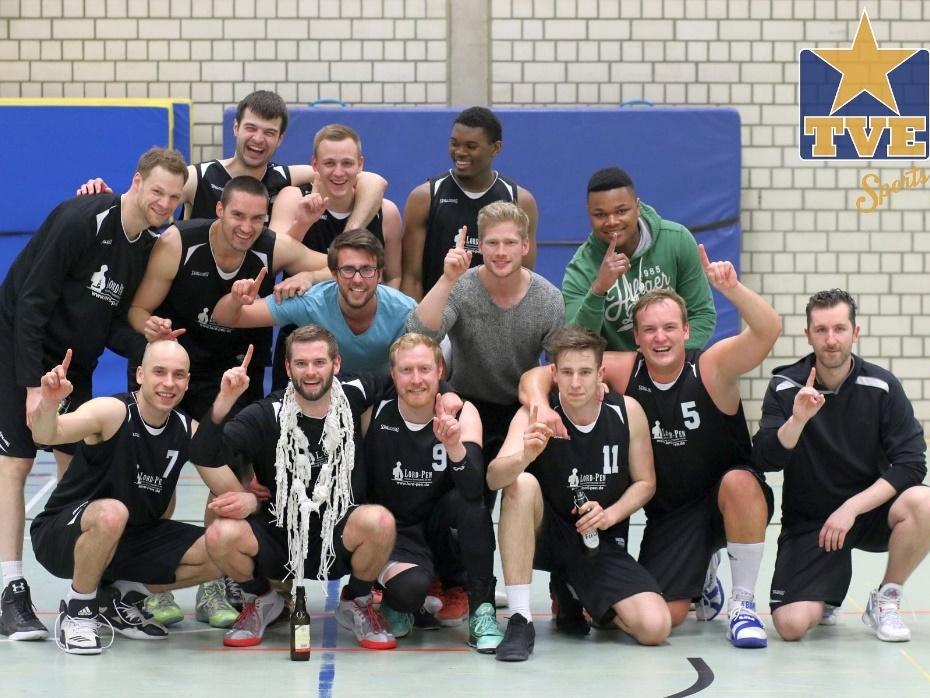 1. Herren 2016/17 Eine Gruppe von 13 Basketballspielern posiert jubelnd auf dem Spielfeld, einige halten einen Pokal und zeigen die Eins.
