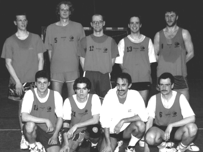 Herren 1994 Gruppennahaufnahme von acht Basketballspielern in Trikots auf einem Basketballfeld.