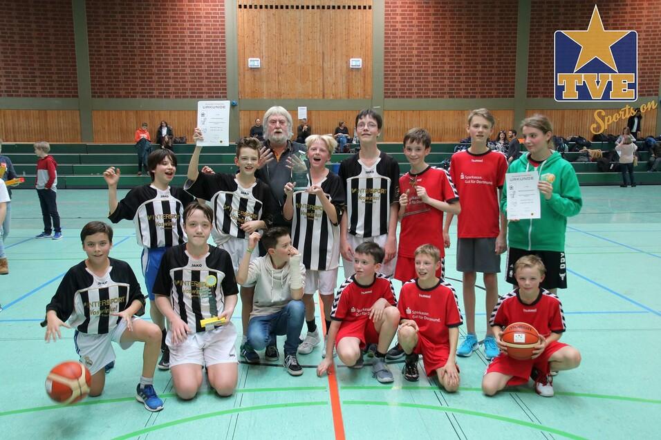 Gruppe von Jugendlichen in Sportkleidung, die nach einem Turnier zusammenstehen, einige halten Pokale und Urkunden.