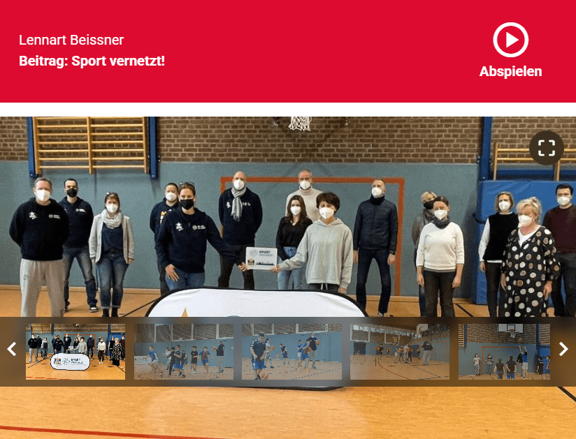 SV - 91.2 2022 Gruppenfoto von 14 Personen in Sportkleidung und Masken, die in einer Turnhalle vor einem Banner posieren.
