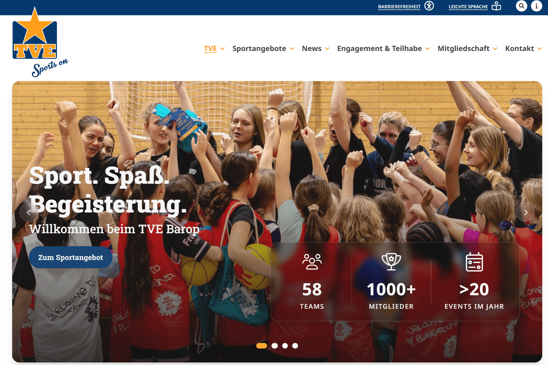 Gruppe von begeisterten Sportlerinnen jubelt gemeinsam in einem Sportzentrum mit Holzwänden.